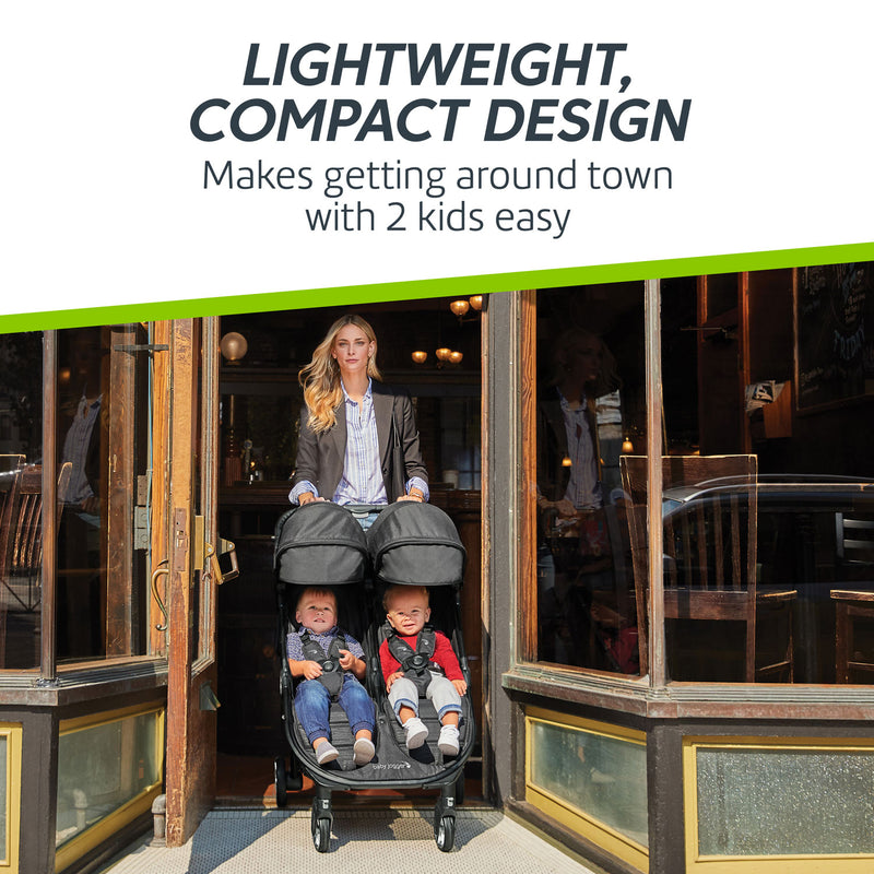 Woman pushes Baby Jogger City Tour 2 Double Stroller through doorway