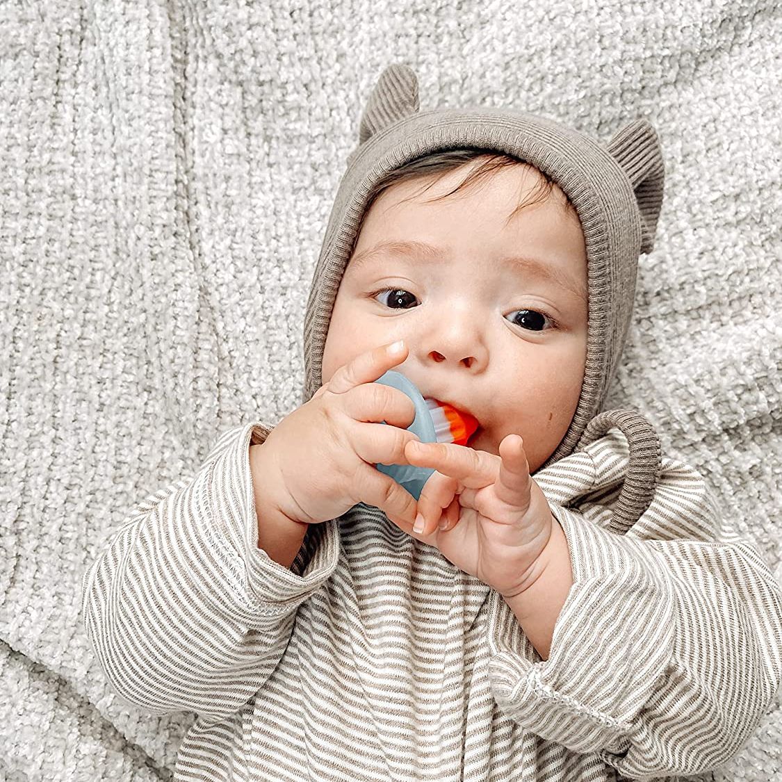 Baby sucking on Itzy Ritzy Teensy Teether - Soothing Silicone Teether - Hero Pop