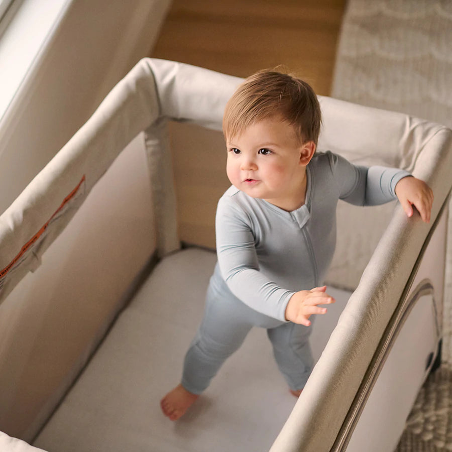 Toddler standing in playard UPPAbaby Organic Cotton Mattress Cover - REMI