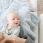 Baby laying on Saranoni Receiving Dream Blanket - Heather Blue