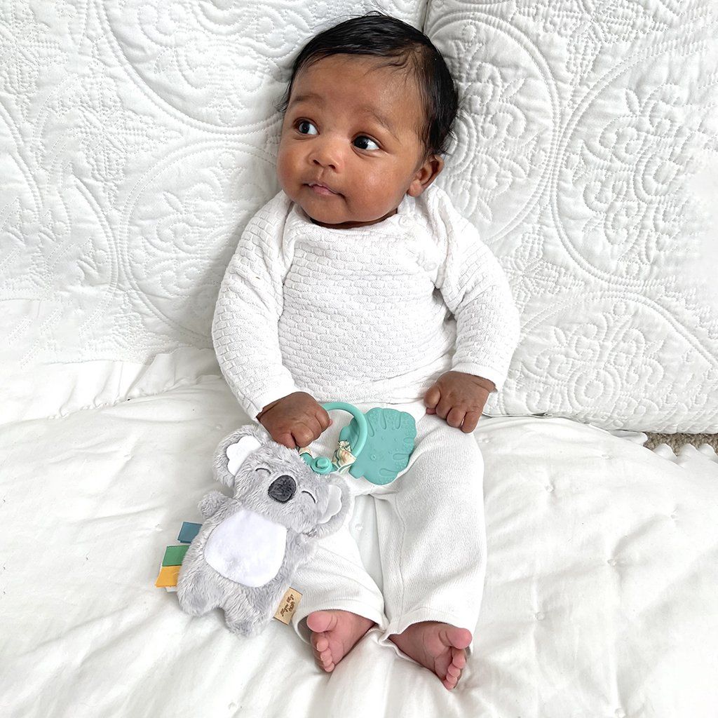 Baby Holding Itzy Ritzy Itzy Pal Infant Toy - Kayden the Koala