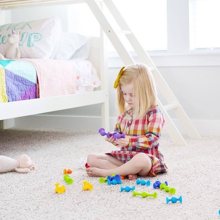 Child Playing with Fat Brain Toys Squigz Starter Set