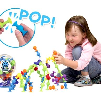 Child Playing with Fat Brain Toys Squigz Starter Set