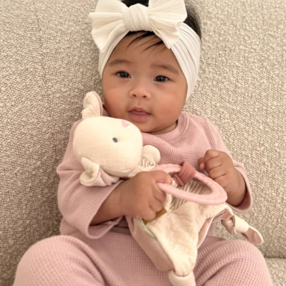Baby Holding Itzy Ritzy Bitzy Crinkle Sensory Toy with Teether - Bunny